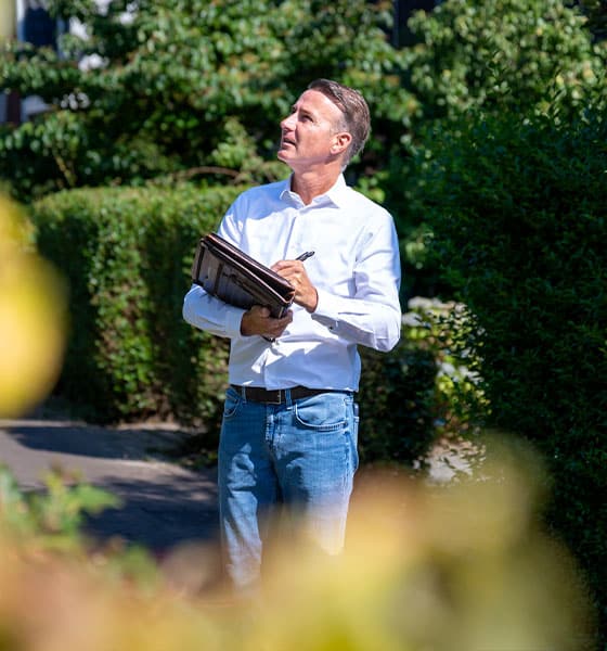 makelaar voert taxatie uit in ruime tuin